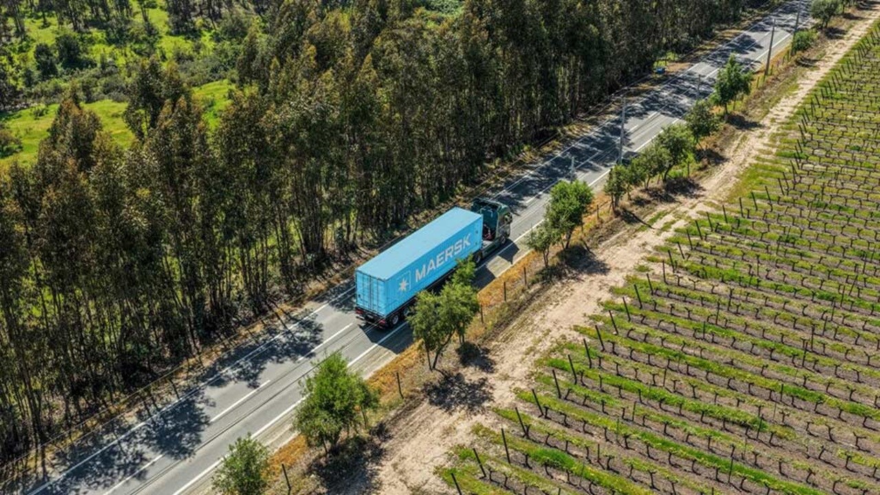 Maersk blue container on a Volvo FH electric truck on a road