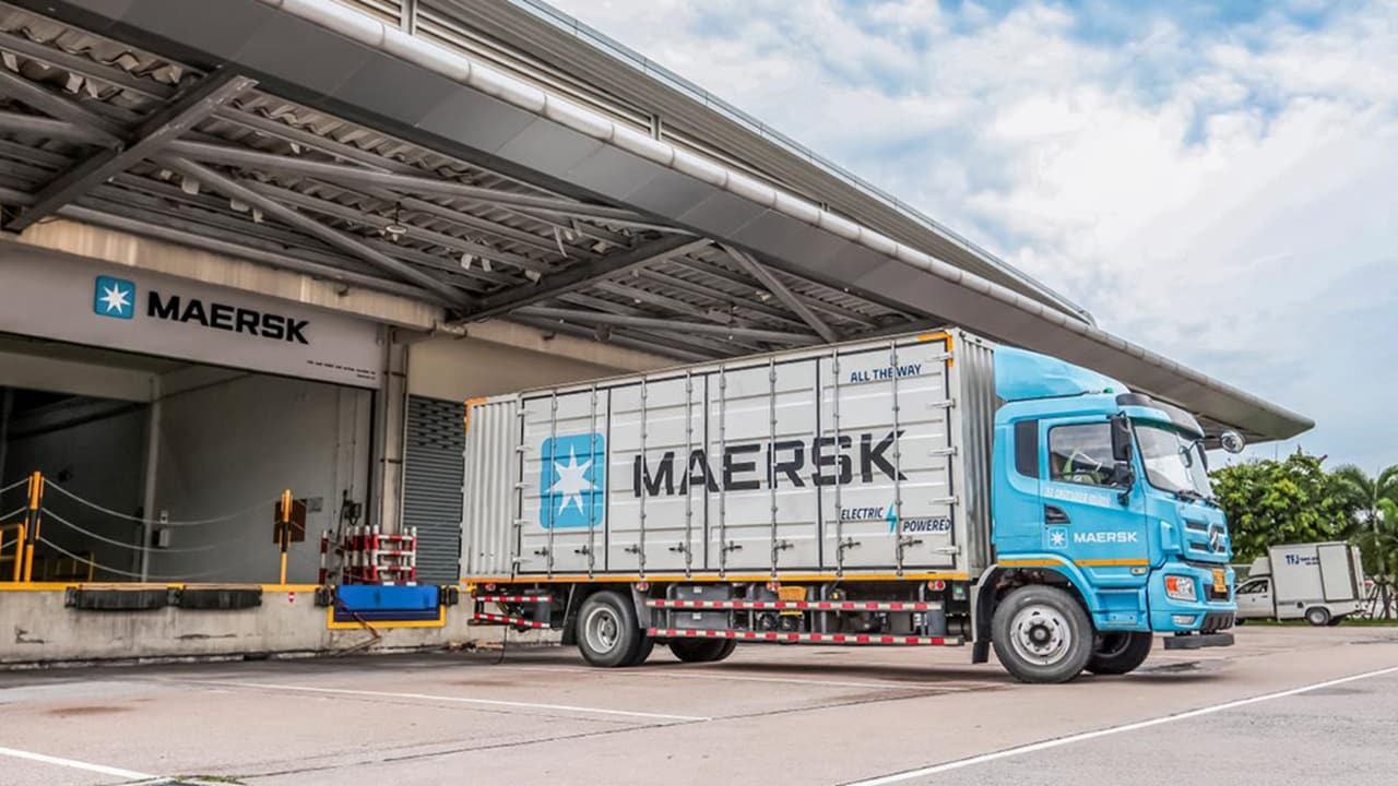 Maersk delivery truck with reefer container parked at a warehouse facility for loading
