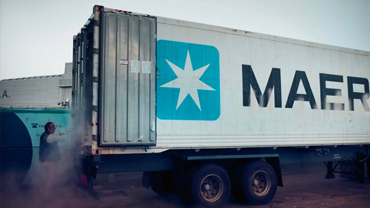 A Maersk container with doors opened and a man near it